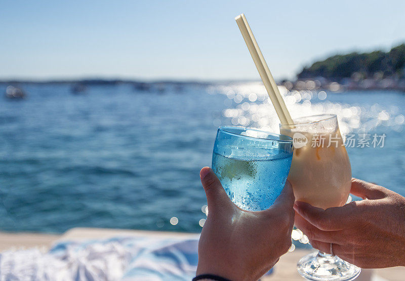 情侣在水边用鸡尾酒敬酒