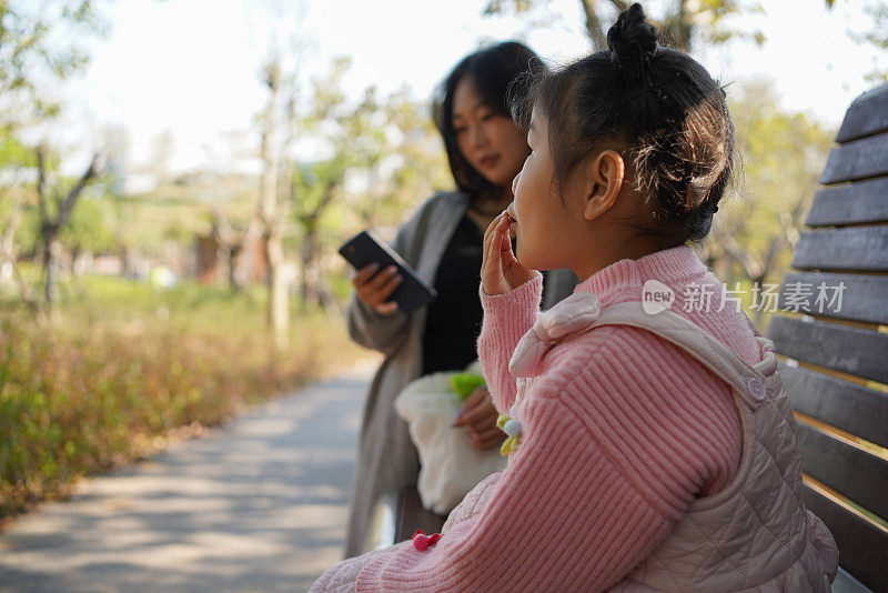 美丽的亚洲女孩和她的妈妈在公园里玩