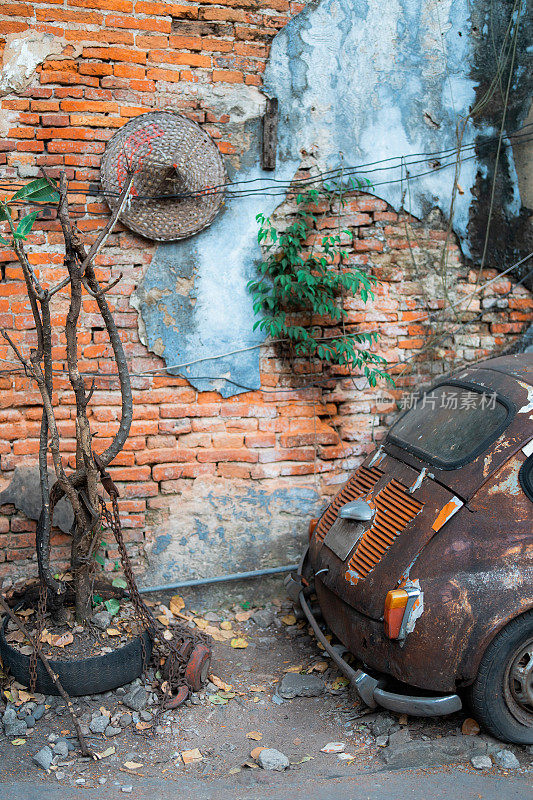 砖墙旁一辆破旧的古董车