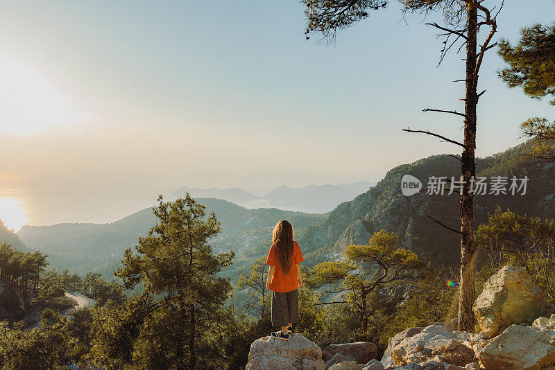 女性在日落期间从上面考虑土耳其风景的后视图