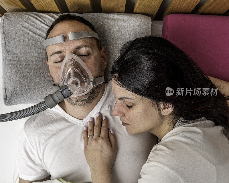 由于阻塞性睡眠呼吸暂停，男子带着cpap面罩睡觉