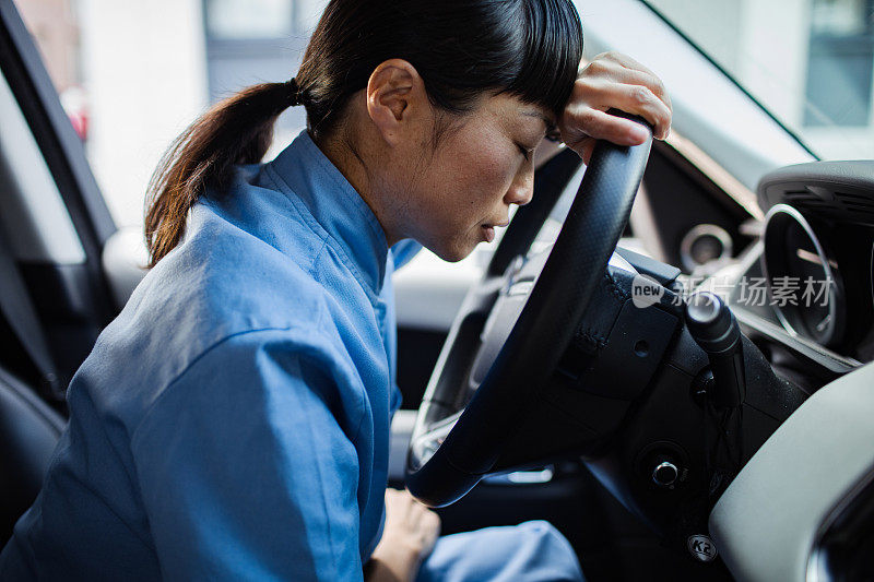 年轻的日本医护人员在车里感到疲惫和压力