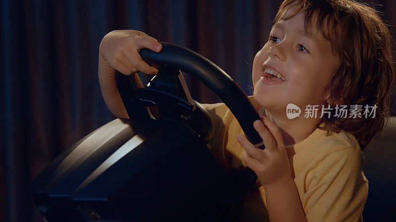 微笑的男孩喜欢驾驶虚拟汽车的方向盘