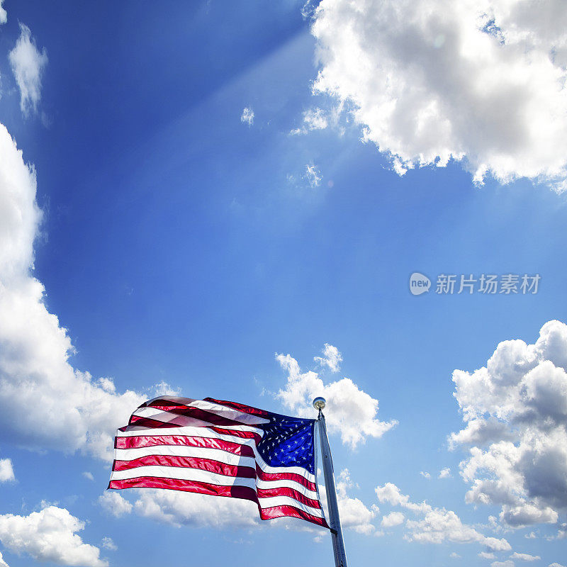 美国国旗插在旗杆上，天空晴朗湛蓝
