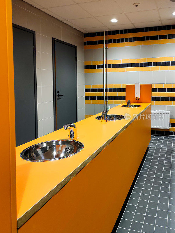 公共厕所内部，台面有洗手池和洗手水龙头。