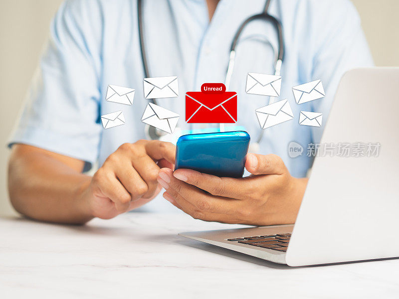 坐在办公桌前使用手机的医生会收到一条带有未读电子邮件图标的新消息。