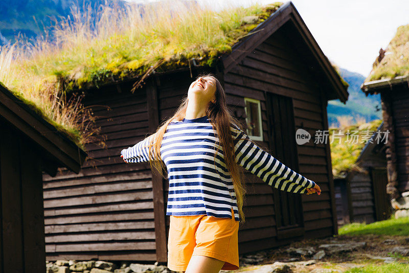 快乐的女游客在挪威的老维京村沉思阳光明媚的夏天