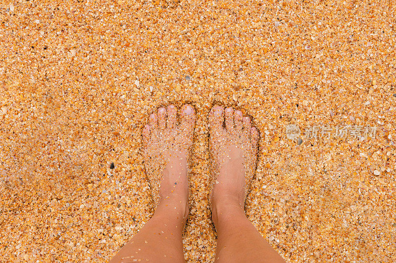 在一个阳光明媚的夏日，一位年轻女子赤脚站在沙滩上。身体的一部分。镜头视角。空白的地方，鼓舞人心的，快乐的文字，引用或说。