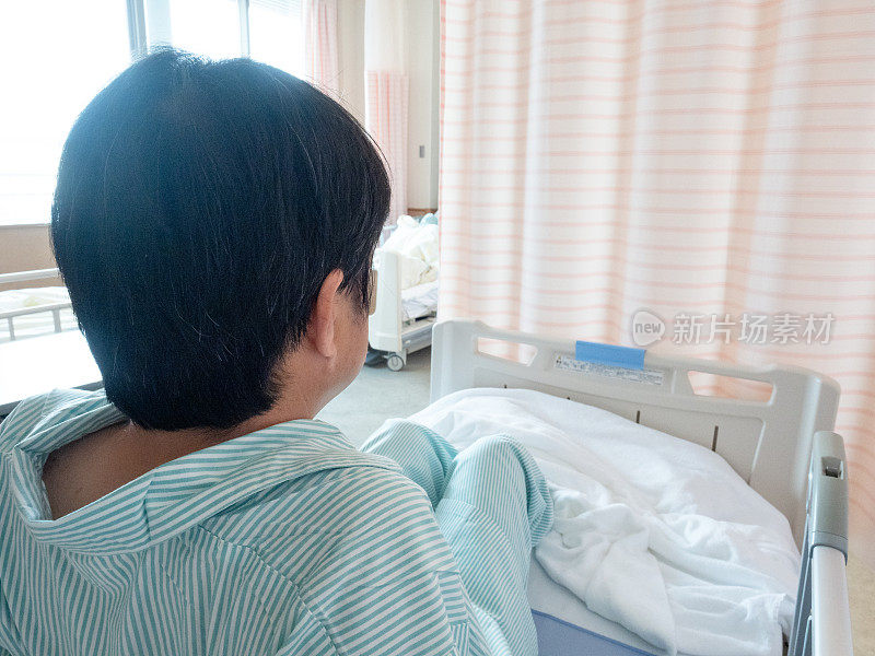 一个亚洲病人坐在病床上