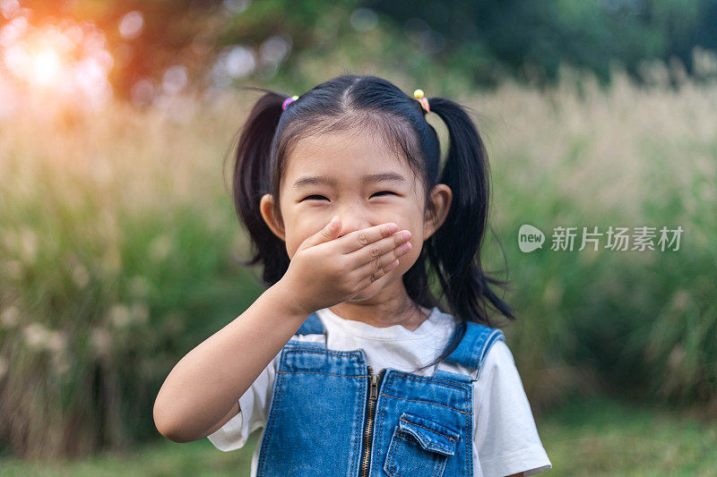 可爱的女孩捂住嘴