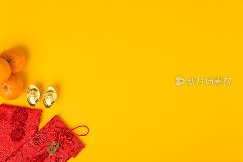 春节喜庆观念，平铺俯视图，喜庆春节用红包和金元宝(“福”字寓意财富、祝福)放在黄色背景上