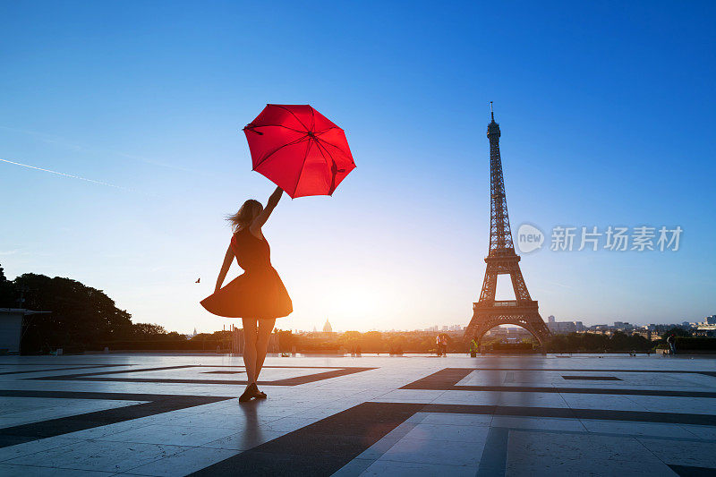 到巴黎旅游，在埃菲尔铁塔附近看到一个拿着红伞的女人的剪影