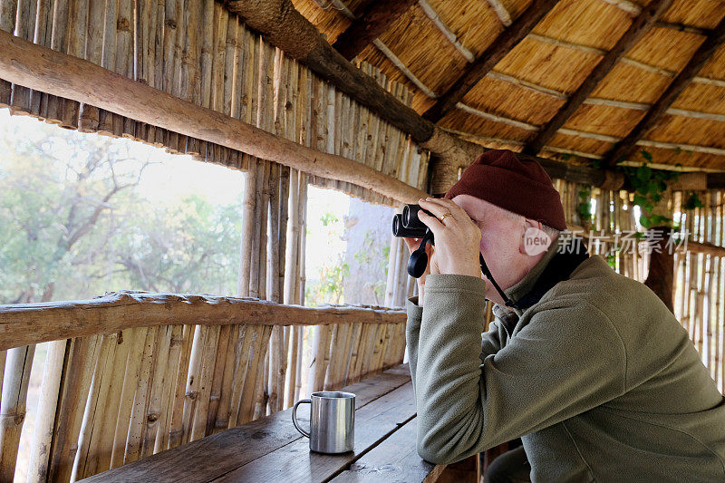 游客在马拉维马吉特野生动物保护区的观景台上用双筒望远镜观看