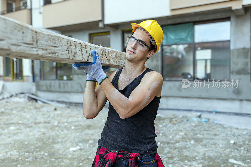 建筑工人在工地搬运木板的肖像