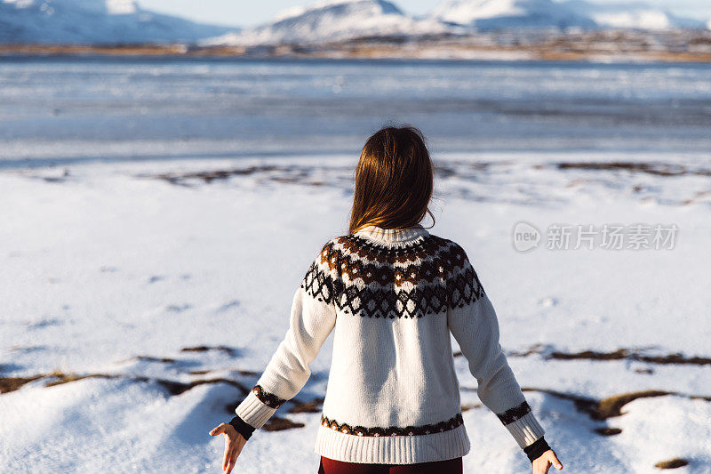 一个女人在享受冰岛美丽的冰湖和雪山的景色