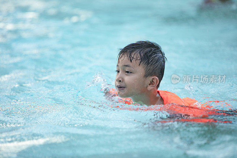 一群亚洲儿童在游泳池旁。他们在玩，享受着水