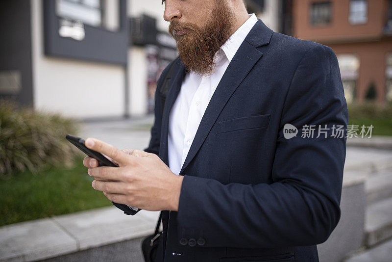 年轻的潮人商人在城市里用触控板上网，库存照片