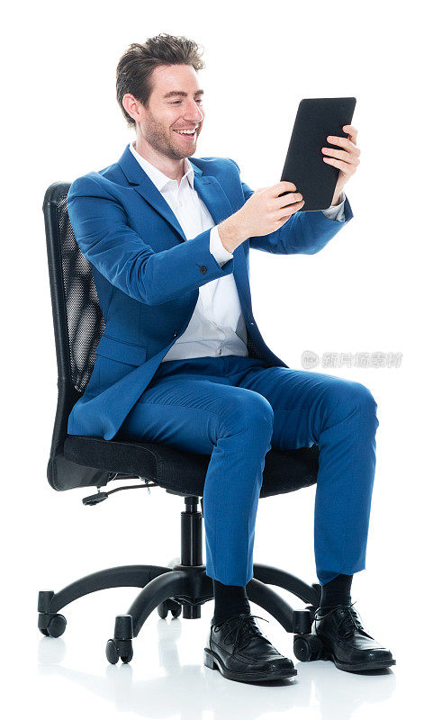 白种年轻男性商人穿着衬衫正在休息，用着数码平板电脑