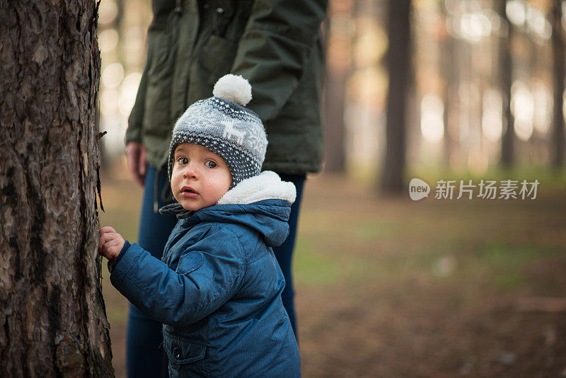 妈妈带着蹒跚学步的孩子穿过森林