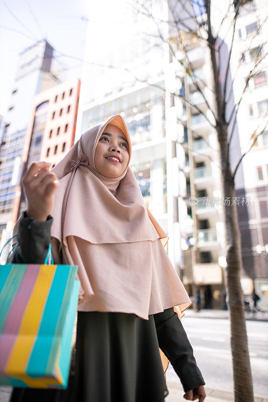 年轻的穆斯林妇女在城市购物