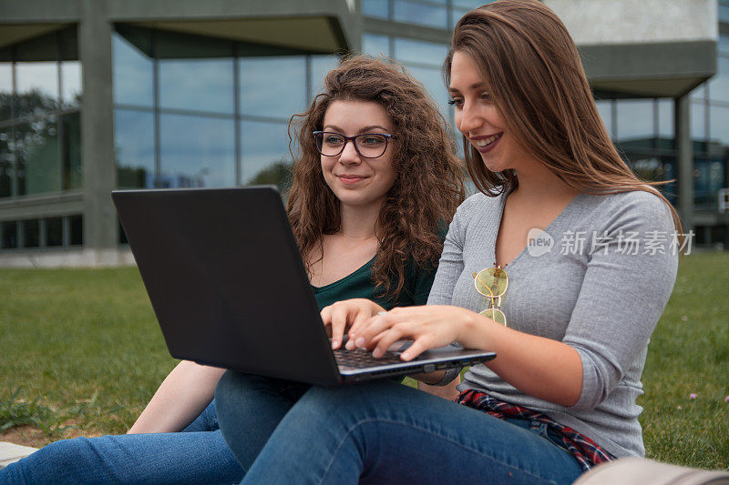 两个女学生在用笔记本电脑工作
