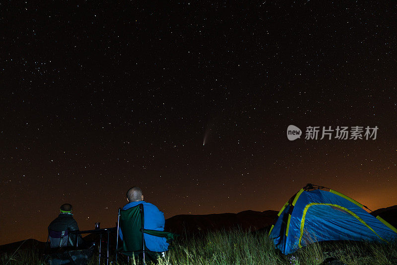 朋友露营和看星星和彗星在夜晚