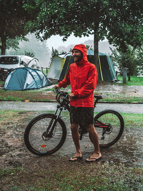 一名山地摩托车手冒着暴雨回来露营