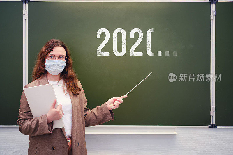 老师戴着医用口罩在黑板前，不确定何时结束隔离。新冠肺炎疫情期间学校问题的概念