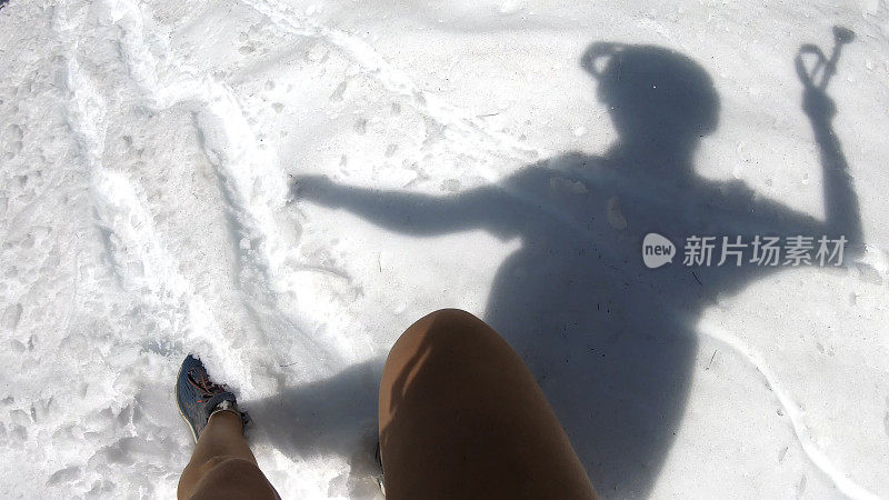 徒步旅行者沿着积雪的山坡跑下去