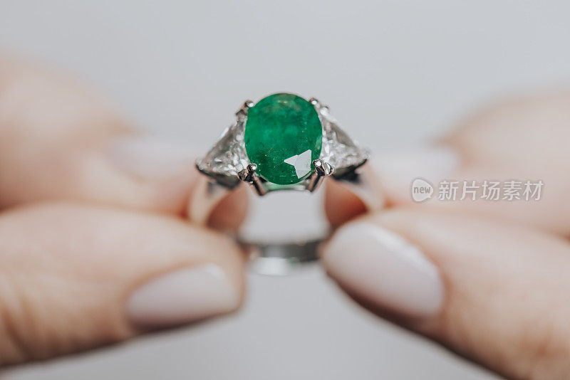 拿着绿色钻石戒指的女人