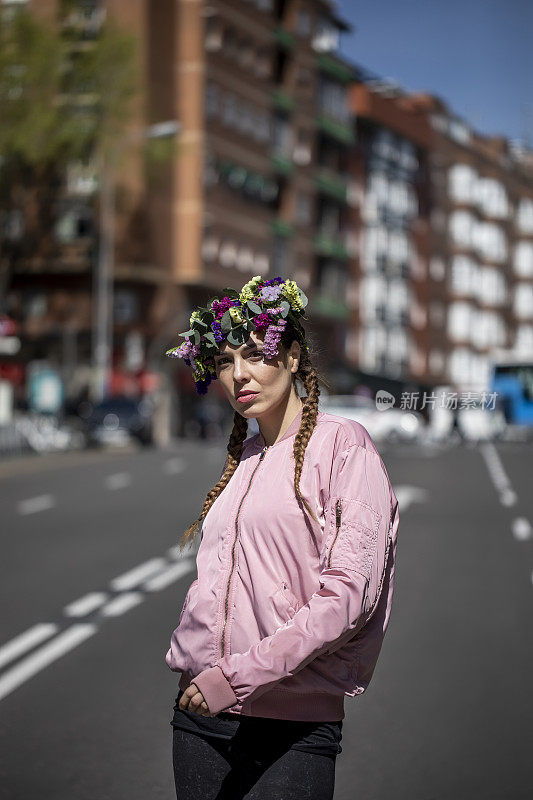 一个三十多岁的女人走在街上，头上戴着花。