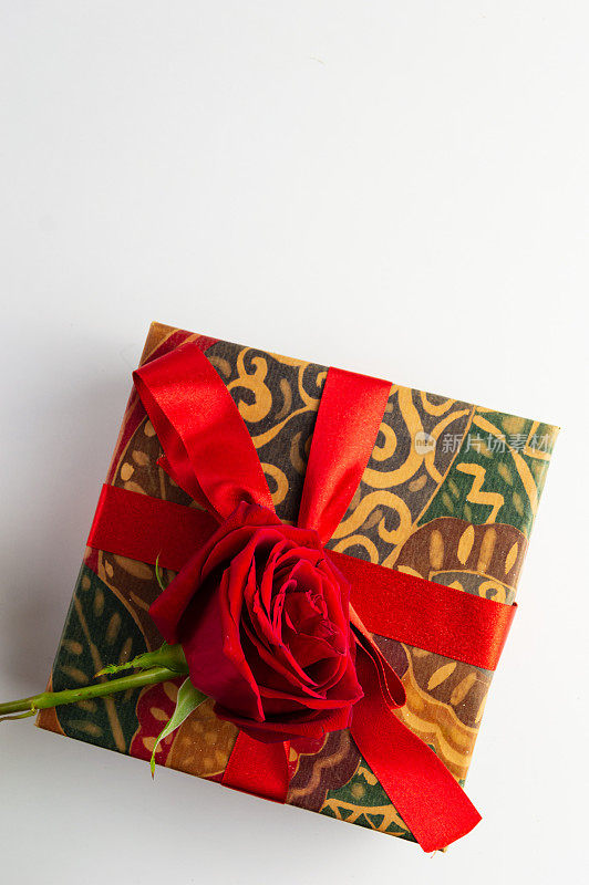 礼盒与红色蝴蝶结和玫瑰在白色的背景