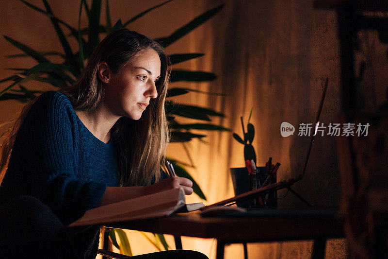 专注于商业女性，从她的笔记本电脑上阅读演示数据，同时安排每月的财务报告，在她的家庭办公室，由于家庭隔离