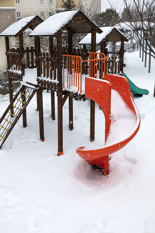 孩子的操场覆盖着雪和玩具在一个冬天的一天