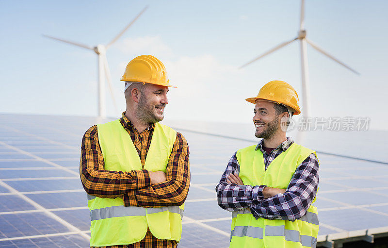 在太阳能发电站的工人-太阳能板与风力涡轮机背景-绿色能源可再生的概念