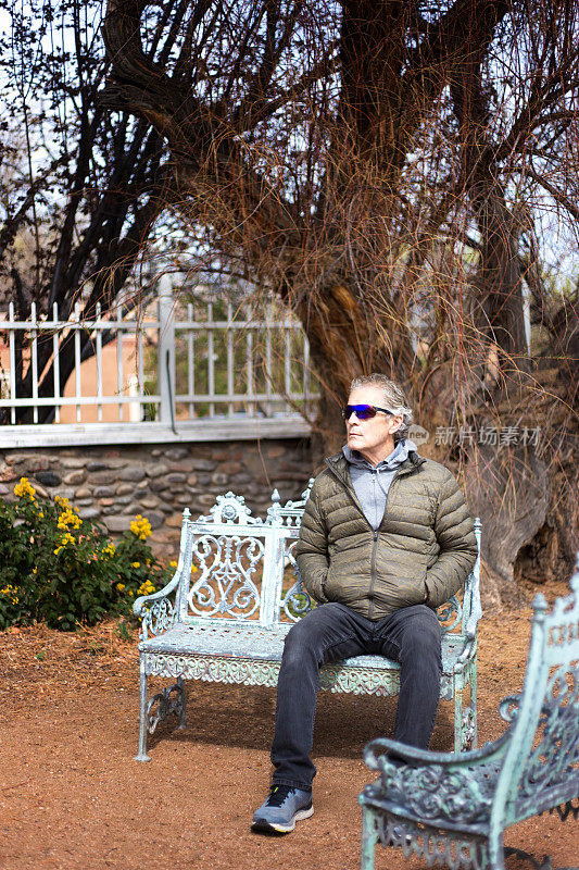 坐在花园里长凳上的老人