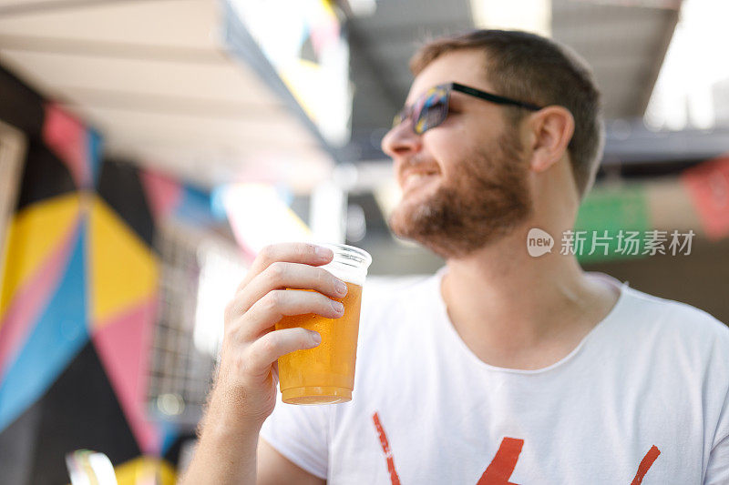 一个男人拿着一个装满啤酒的塑料杯的肖像