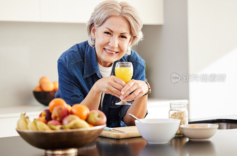 图为一位老年妇女在家里喝橙汁