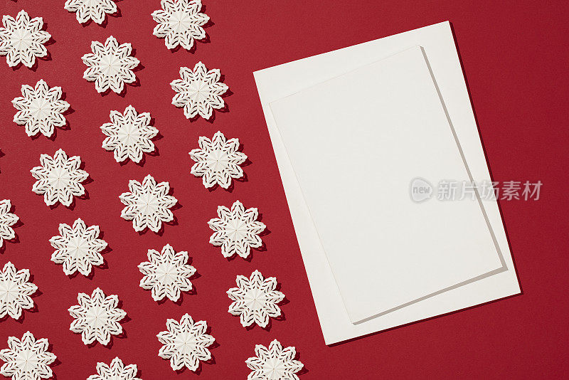 杂志封面模型与白色雪花圣诞装饰平放在红色背景