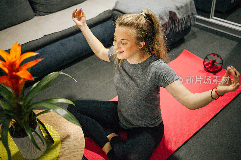 穿着运动服的年轻女子在家练习瑜伽