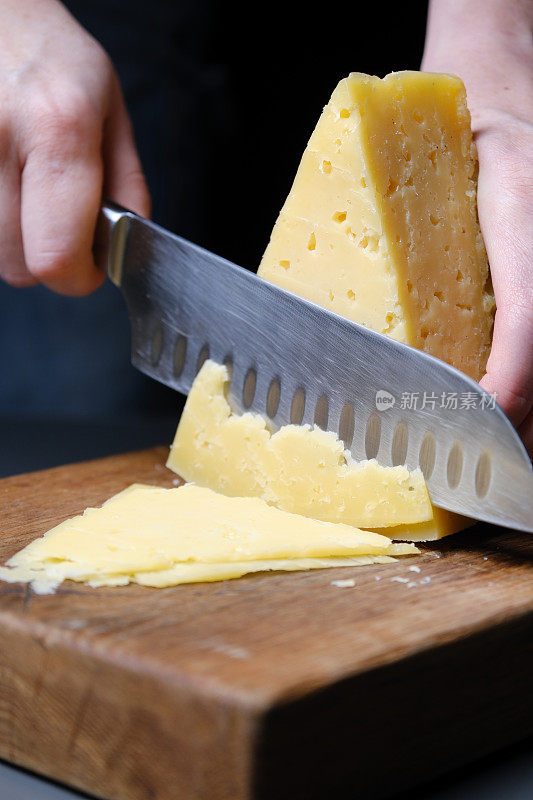 人手正在切一片奶酪