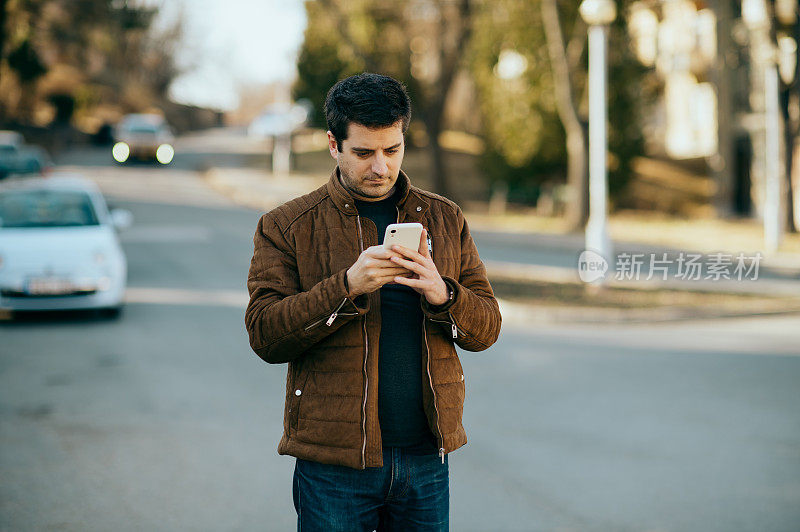 年轻人拿着智能手机看短信。