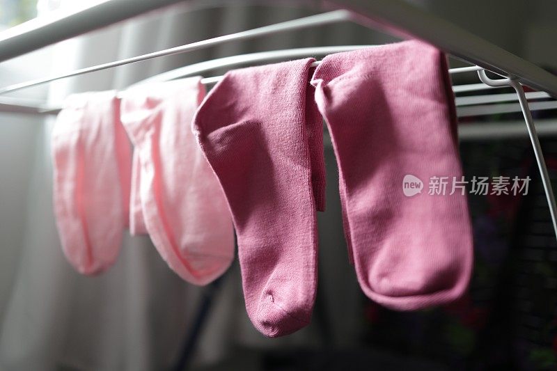 烘干机架上的两双粉色袜子