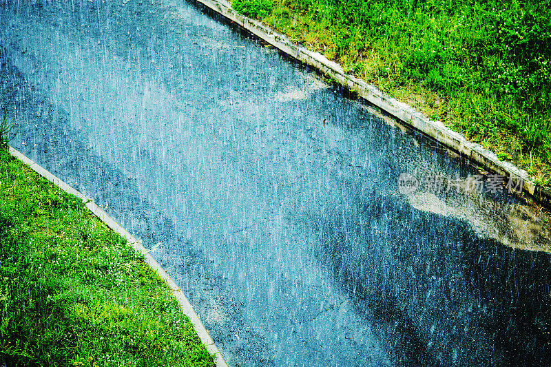 湿滑的道路。雨在城市。夏季潮湿多雨的天气。雨滴正在下降。沥青上的水坑。秋天的雨。