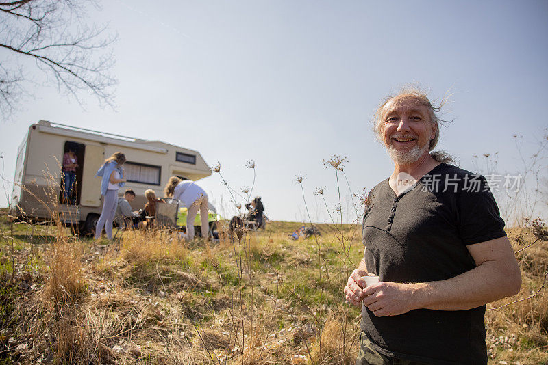 一个骄傲的男人和他的家人享受野餐的肖像