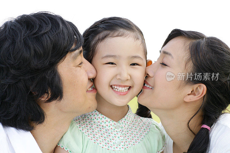 父母亲吻女儿(6-7岁)，特写镜头，微笑