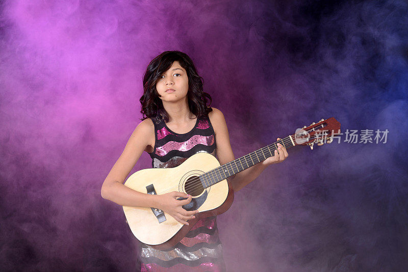 年轻女孩在舞台上弹吉他