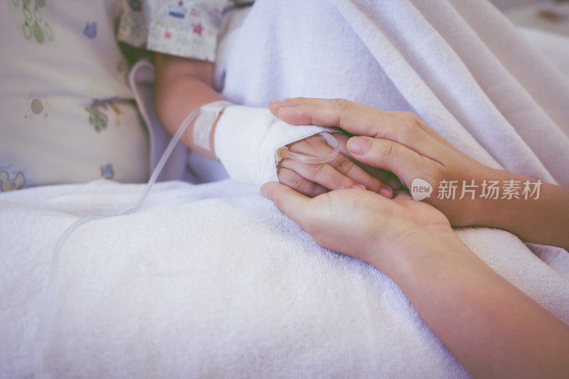 医院里牵着孩子手的家长的手要拉近。