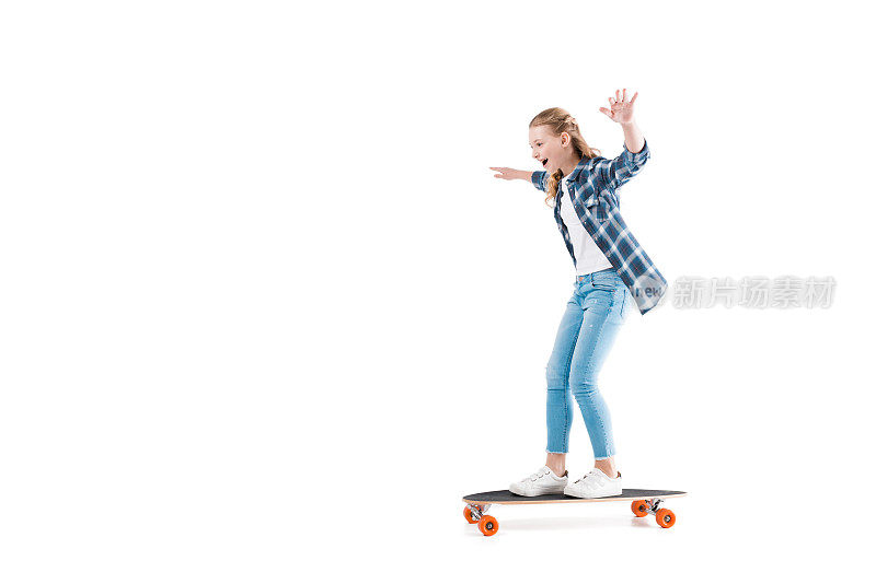 可爱的快乐的女孩与滑板隔离在工作室白色