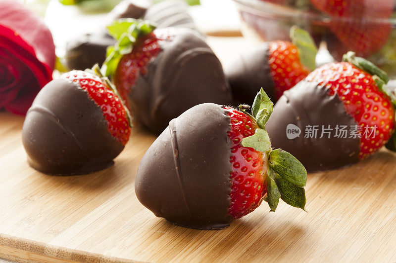 黑巧克力覆盖的草莓躺在切菜板上